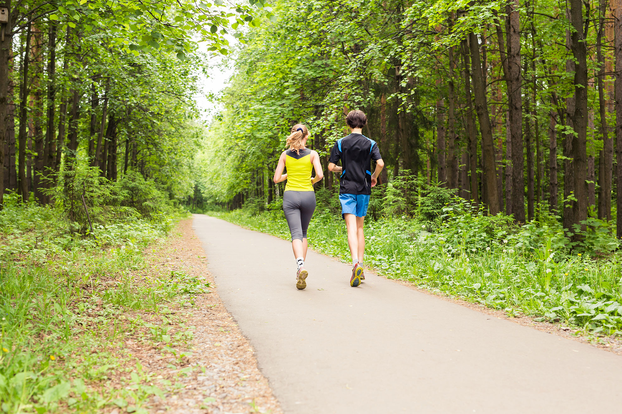 Para biegaczy biegnąca w lesie, ilustracja do artykułu o czasie w biegu na 10 km