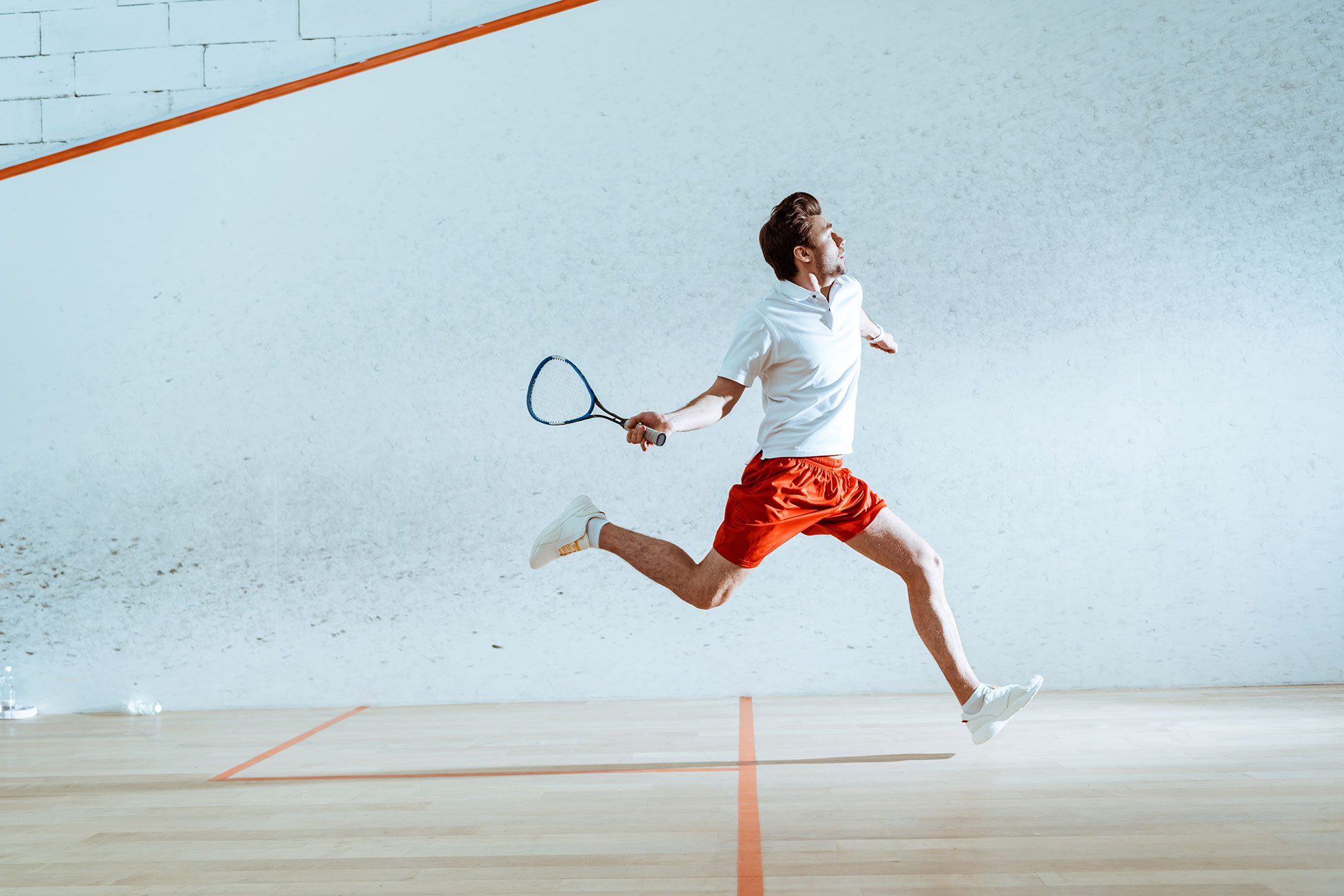 Mężczyzna grający w squasha, ilustracja do artyku o białej piłce do squasha