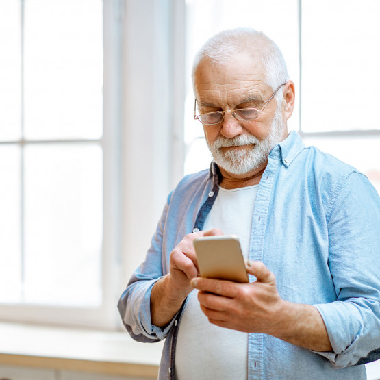 Starszy mężczyzna odbierający telefon, ilustracja do artykułu co to jest spoofing